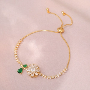Detail of adjustable gold bracelet featuring white zircon flowers and green marquise leaves