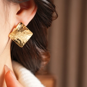 Vue détaillée des boucles d'oreilles plaquées or 18 carats avec texture losange martelée