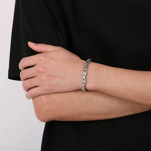Gros plan d'un bracelet chaîne byzantine argentée de 6 mm en acier inoxydable poli au poignet