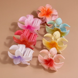 Detailed view of colorful frangipani hair claws with matte translucent acrylic finish