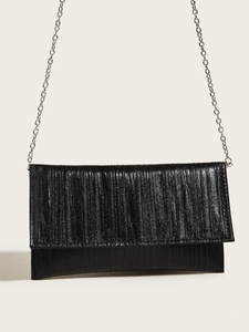 Close-up of black textured evening clutch bag with elegant silver chain strap detail