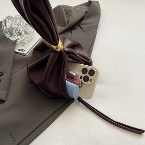 Chic burgundy bucket bag with gold ring closure and interior space for cosmetics
