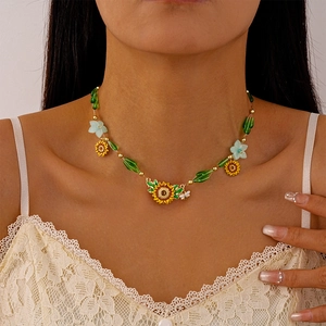 Detail of sunflower and bee necklace with colorful enamel and beads on a model