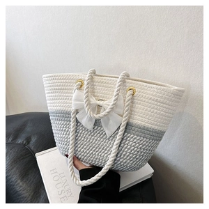 Detail of woven tote bag with a white fabric bow and gradient color texture
