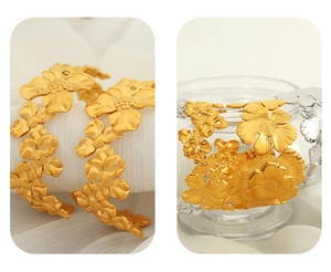 Macro detail of matte brushed floral camellia cuff bracelet in gold and silver finish
