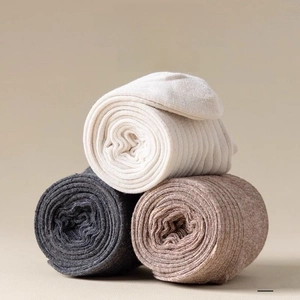 Detailed view of ribbed knit fabric texture in cream, dark grey and brown earth tones