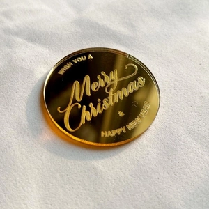 Macro view of gold mirror acrylic cake topper with laser engraved Christmas greetings