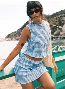 Detailed view of blue and white plaid sleeveless top with ruffled mini skirt set