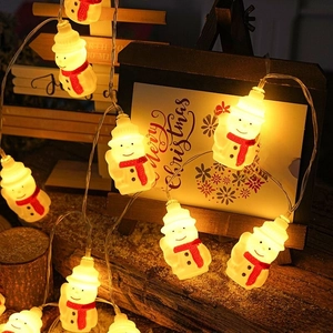 Close-up of warm glowing snowman LED string lights with cozy red scarf details