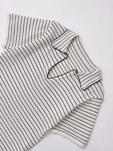 Détail d'un polo à manches courtes crème à rayures noires et col à bordure ondulée