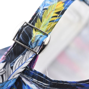 Detailed close-up of the adjustable strap and silver metal buckle on the colorful leaf cap