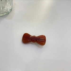 Detailed view of amber resin bow hair clip with gold France Handmade engraving