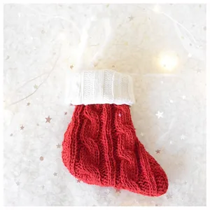 Macro detail of red and white cable-knit Christmas stocking with plush hanging loop