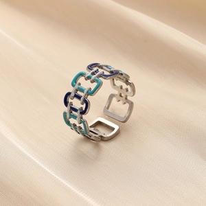 Macro detail of enamel link ring with blue and white tones on soft silk fabric