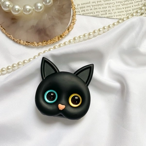 Dettaglio del supporto per telefono a forma di gatto 3D nero con occhi eterocromatici su seta