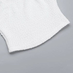 Close-up of white textured knit fabric showing soft, fluffy bouclé material details