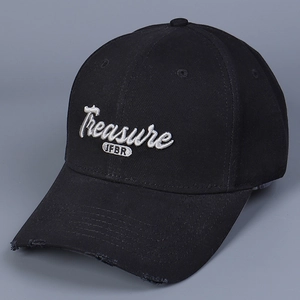 Close-up of white Treasure embroidery on black cotton baseball cap with distressed brim
