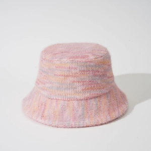 Detailed view of pink plush knit bucket hat with yellow and grey striped fuzzy texture