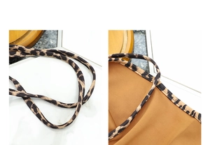 Close-up of thin shoulder straps and leopard print fabric detail on a stylish tote bag