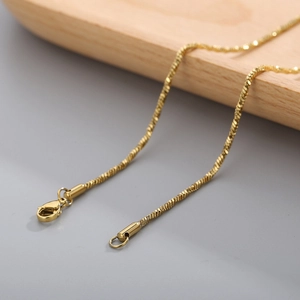 Detailed macro view of golden twisted snake chain necklace with lobster clasp