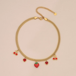 Detail of gold-plated stainless steel necklace with strawberry and cherry glass charms