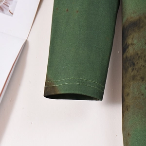 Zoom sur le poignet à imprimé tie-dye vert foncé avec finitions à double surpiqûre