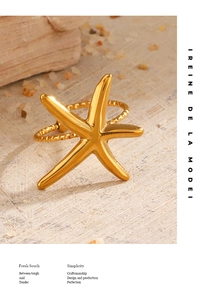 Détail macro d'une bague étoile de mer dorée avec anneau texturé sur fond de pierre