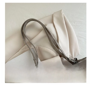 Detail of grey vintage tote bag showing leather handle and chain strap on blazer