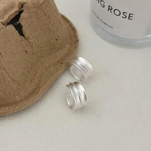 Macro detail of 925 sterling silver matte earrings with industrial double-ridged design