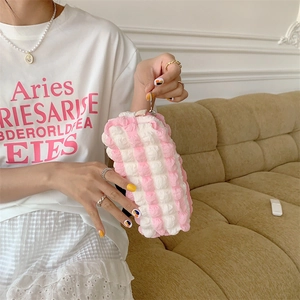 Handheld view of a soft bubble-textured pink and white quilted stationery pouch storage bag