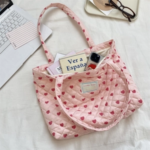Gros plan du sac cabas matelassé rose à cœurs rouges montrant l'intérieur spacieux