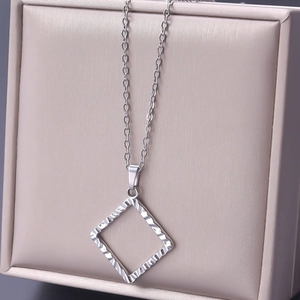 Detailaufnahme eines silbernen Rautenanhängers mit O-Kette in einer Schmuckschatulle