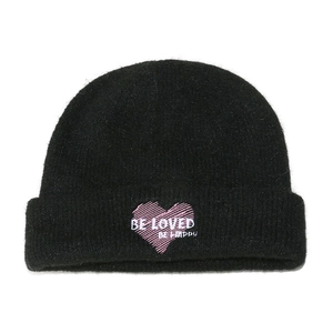 Detalle del gorro de punto negro con bordado de corazón rosa y detalle de texto bordado