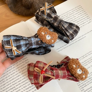 Detail shot of cute plaid fabric hair claws with 3D teddy bear and heart elements