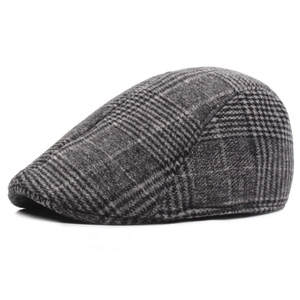 Detailed close-up of dark grey plaid flat cap showing fine houndstooth wool fabric texture