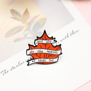 Detail of maple leaf enamel pin with Lord of the Rings Lorien quote on artistic card