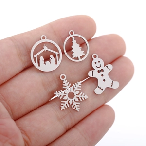 Macro shot of silver stainless steel Christmas charms held in hand for DIY jewelry