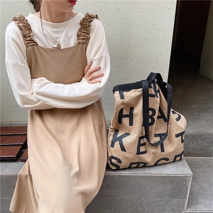 Large capacity canvas tote bag with letter logo shown with minimalist two-piece dress set