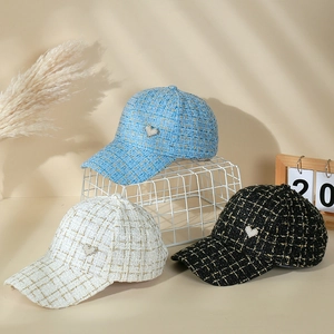 Detailed view of tweed baseball caps with rhinestone heart patches in white blue and black