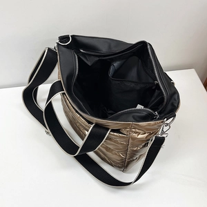 Top view of metallic quilted tote showing large interior compartment and zip pocket