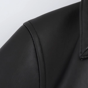 Dettaglio ravvicinato della cucitura della spalla e del bavero di un cappotto nero