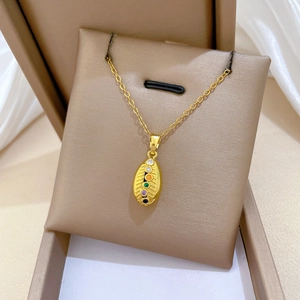 Macro shot of gold-plated titanium necklace with colorful stones in a luxury box