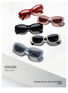 Detailed flat lay of retro oval sunglasses in red, pink, black, cream, and blue frames