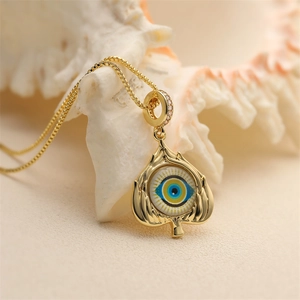 Elegant gold Evil Eye pendant necklace with blue stones and crystals on white shell