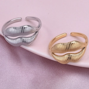 Lip-shaped adjustable stainless steel rings in gold and silver on pink satin background