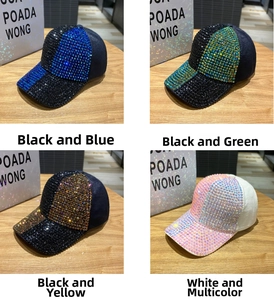 Dettaglio di cappellini da baseball scintillanti con strass in blu, verde, oro e rosa
