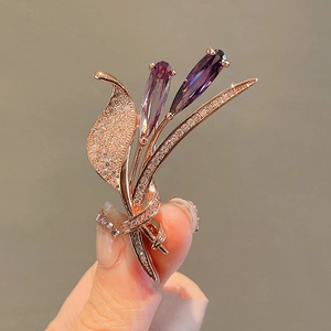 Elegante spilla in oro rosa con gemme a goccia viola e cristalli scintillanti