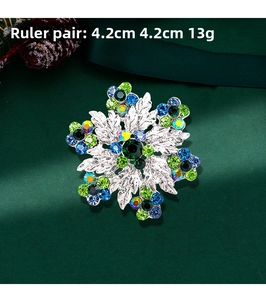 Detailed size view of silver snowflake brooch with blue crystals and green rhinestones