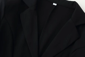 Close-up detail of the black lace stitching and twill fabric texture on the jacket collar