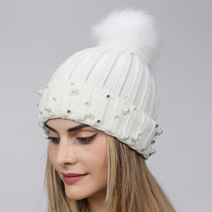 White winter knit beanie featuring faux fur pom-pom and elegant pearl embellishments